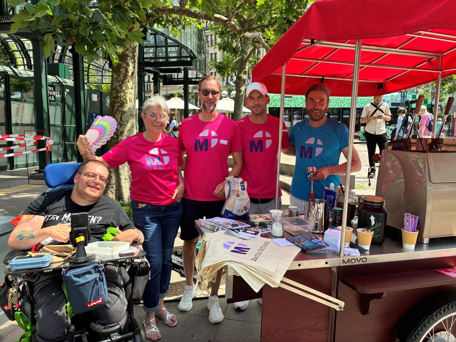 Team der Martha Stiftung in pinken T-Shirts am Coffee Bike mit rotem Schirm bei den Hamburger Stiftungstagen