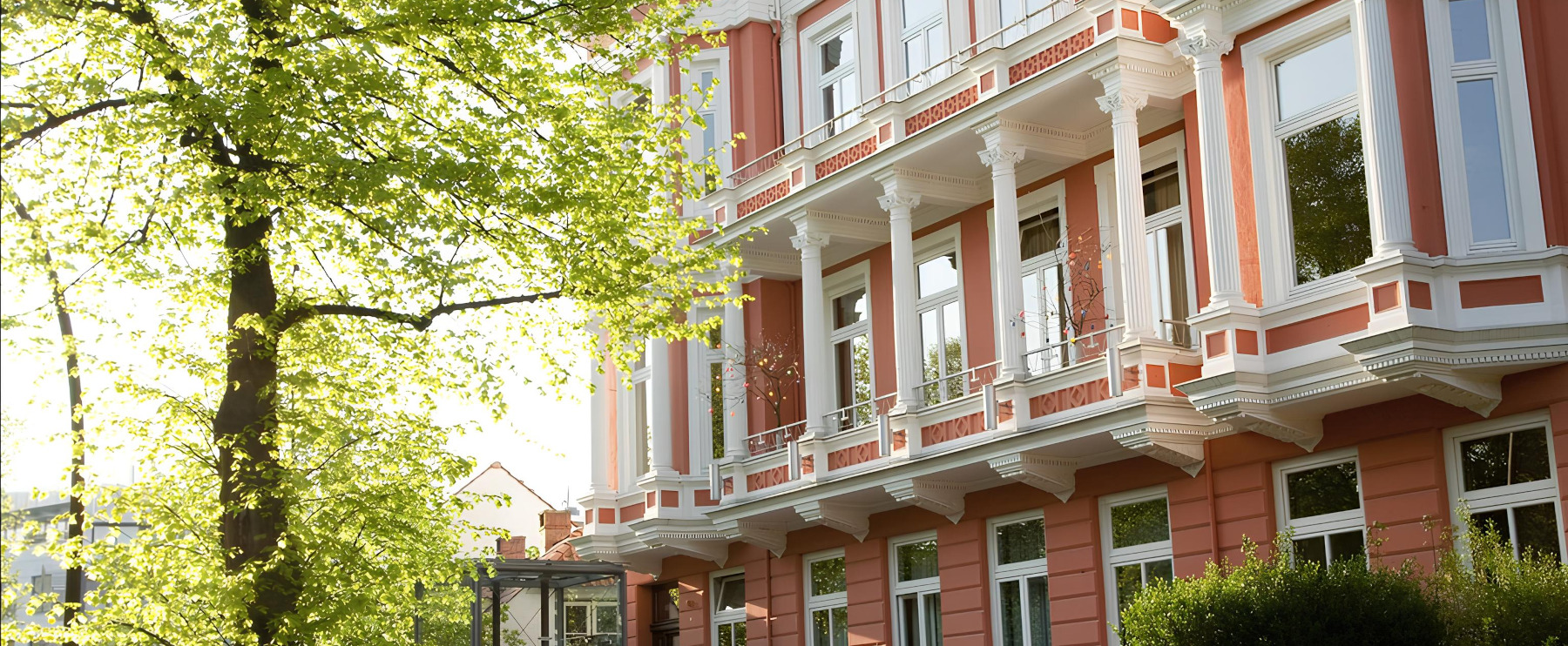 Rote Eingangst?r des Familienhafens mit dekorativer Girlande und dem Schild ?Familienhafen ? Ambulanter Kinderhospizdienst Hamburg?.